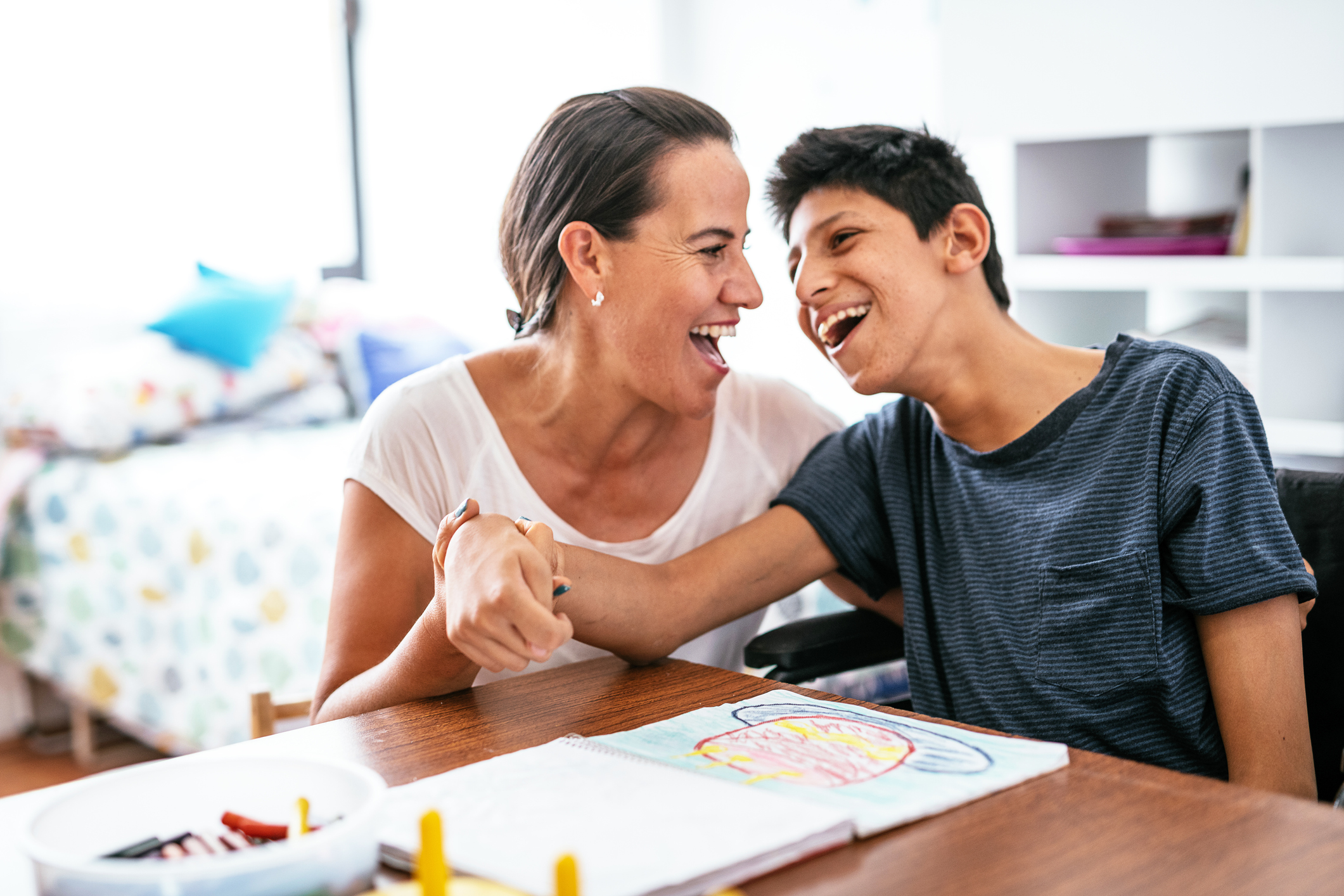 Disabled Latino teenager with Celebral Palsy and mother laughing. Cerebral palsy are lifelong conditions that affect movement and co-ordination, caused by a problem with the brain that occurs before, during or after birth.